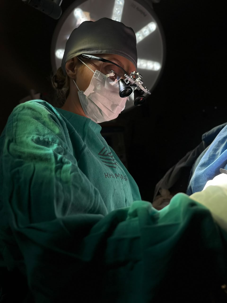 Dra. Gabriella Alves em roupa cirúrgica durante um procedimento de transplante capilar
